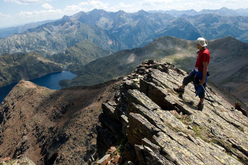 Een wandelaar op de top van een klif in de Pyreneeën